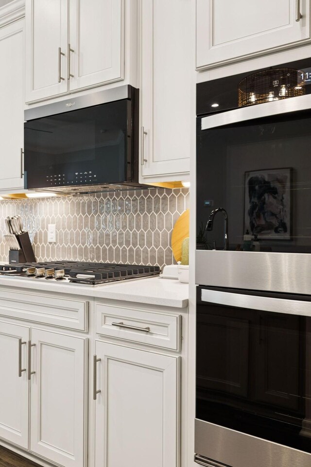 1434 Autumn Leaf Ln, Mount Juliet, TN 37122 - kitchen with appliances with stainless steel finishes, light countertops, white cabinetry, and decorative backsplash