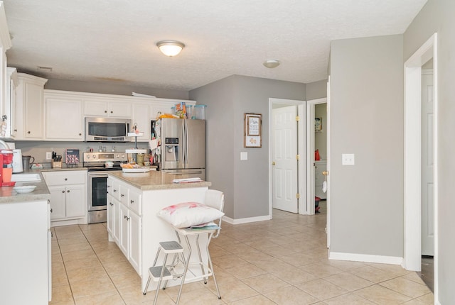 982 Chesire Way, Gallatin, TN 37066 - kitchen with stainless steel appliances, light tile patterned flooring, light countertops, white cabinets, and a textured ceiling