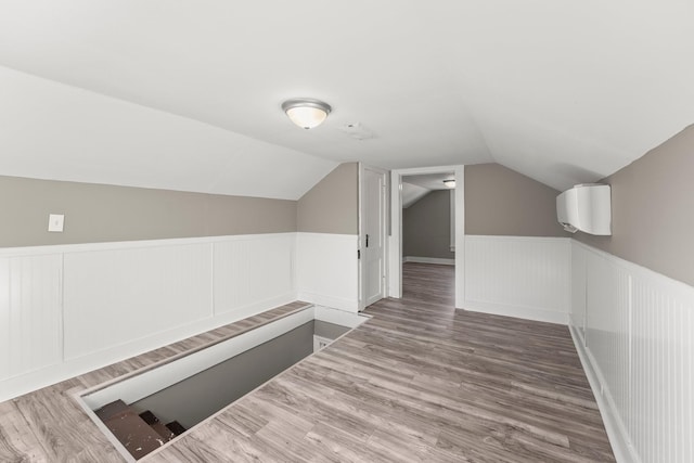 715 N High St N, Winchester, TN 37398 - additional living space with lofted ceiling, a wainscoted wall, wood finished floors, and a decorative wall