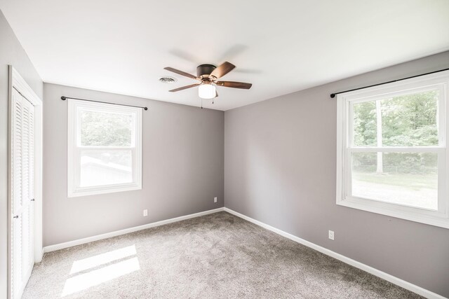 13989 Owens Chapel Rd, Springfield, TN 37172 - unfurnished bedroom with multiple windows, carpet, a closet, and a ceiling fan