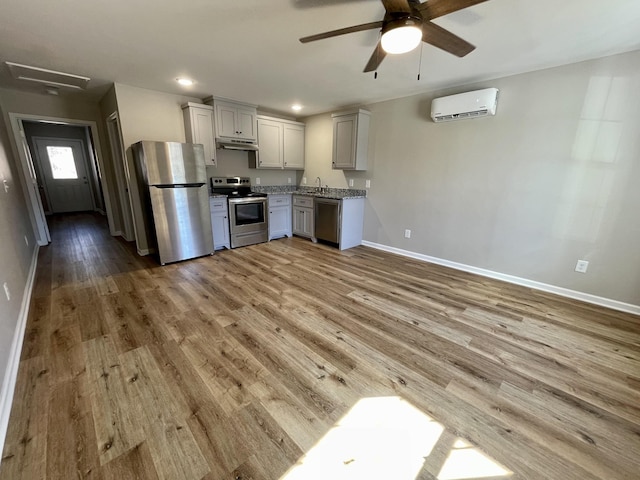 1280 E Gaines St, Lawrenceburg, TN 38464 - kitchen featuring appliances with stainless steel finishes, a wall mounted air conditioner, under cabinet range hood, ceiling fan, and light wood-type flooring