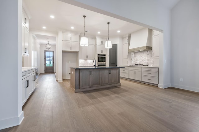 5743 Sagebrush Dr, Murfreesboro, TN 37129 - kitchen featuring custom exhaust hood, gas stovetop, decorative backsplash, light wood finished floors, and white cabinetry