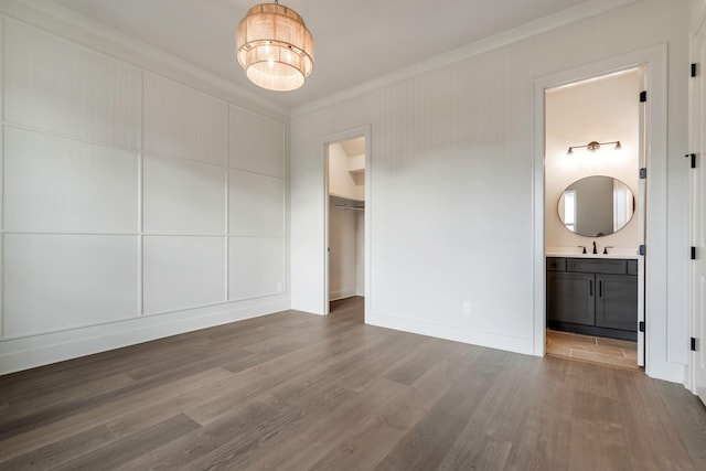 5743 Sagebrush Dr, Murfreesboro, TN 37129 - unfurnished bedroom with crown molding, wood finished floors, connected bathroom, a closet, and a walk in closet