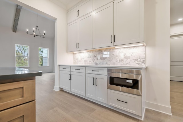 5743 Sagebrush Dr, Murfreesboro, TN 37129 - kitchen with tasteful backsplash, a chandelier, light wood-style flooring, hanging light fixtures, and beam ceiling