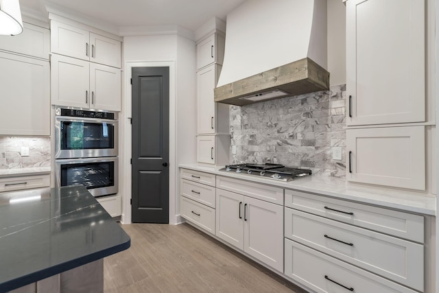 5743 Sagebrush Dr, Murfreesboro, TN 37129 - kitchen with custom range hood, appliances with stainless steel finishes, tasteful backsplash, and light wood-style flooring