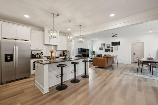 234 Sounder Cir, La Vergne, TN 37086 - kitchen featuring stainless steel fridge with ice dispenser, dark countertops, a breakfast bar area, white cabinetry, and light wood-type flooring