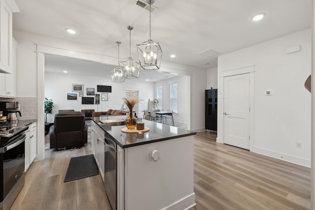 234 Sounder Cir, La Vergne, TN 37086 - kitchen with appliances with stainless steel finishes, a center island, dark countertops, white cabinets, and light wood finished floors