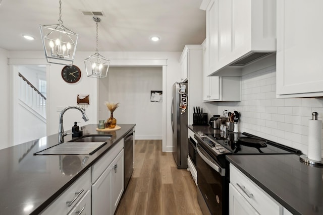 234 Sounder Cir, La Vergne, TN 37086 - kitchen featuring appliances with stainless steel finishes, premium range hood, dark countertops, a chandelier, and recessed lighting