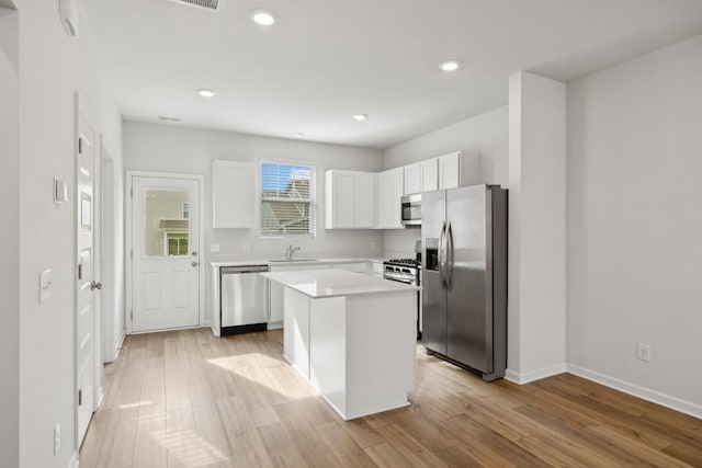 2509 Drumwright Way, Columbia, TN 38401 - kitchen featuring appliances with stainless steel finishes, white cabinetry, a kitchen island, light countertops, and light wood finished floors