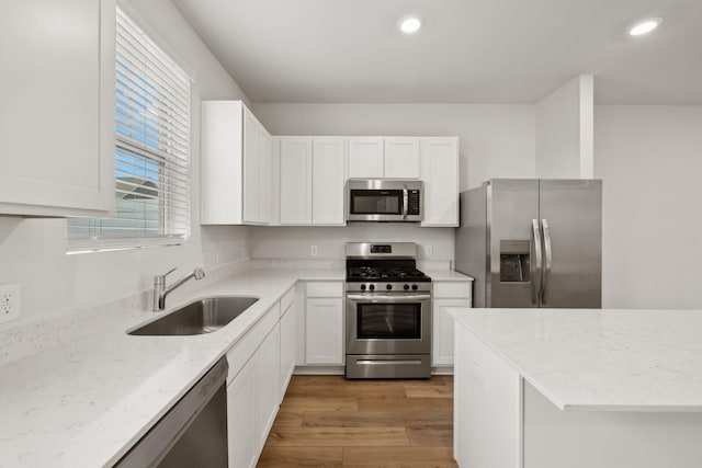 2509 Drumwright Way, Columbia, TN 38401 - kitchen with appliances with stainless steel finishes, white cabinets, light stone counters, recessed lighting, and light wood-type flooring