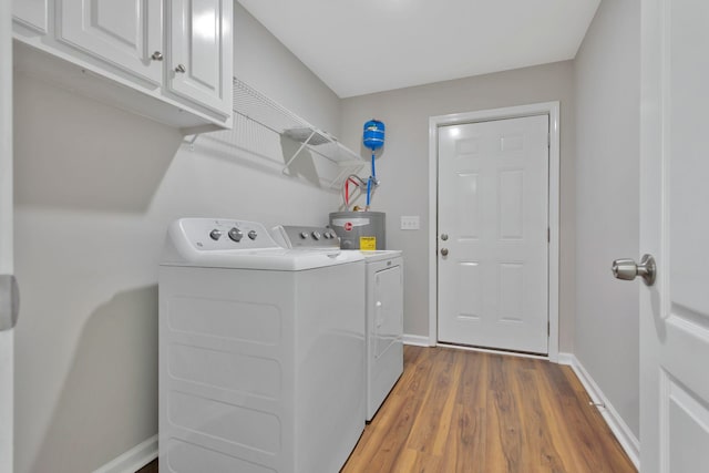 288 Springwater Dr, Summertown, TN 38483 - laundry room with cabinet space, washing machine and dryer, water heater, and wood finished floors