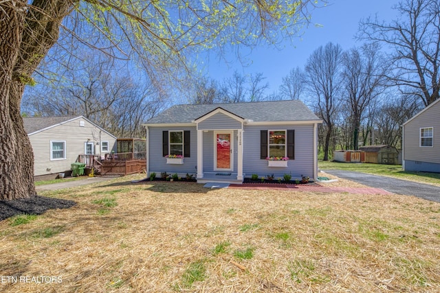 1112 Brookside Ave, Maryville, TN 37804 - bungalow with a front yard, a wooden deck, a shingled roof, a storage shed, and asphalt driveway