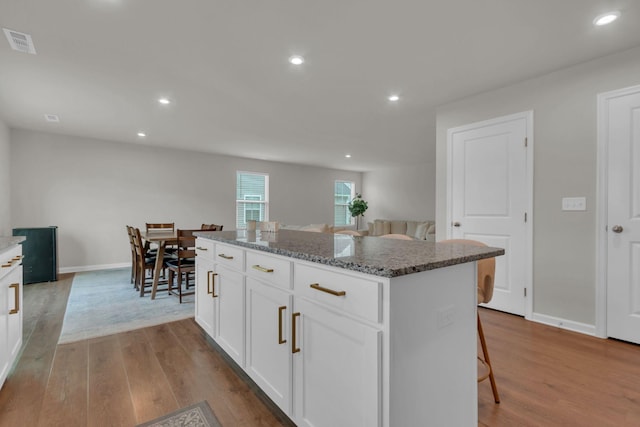 1830 Quail Run Way, Spring Hill, TN 37174 - kitchen with a kitchen island, wood finished floors, a kitchen breakfast bar, stone countertops, and recessed lighting
