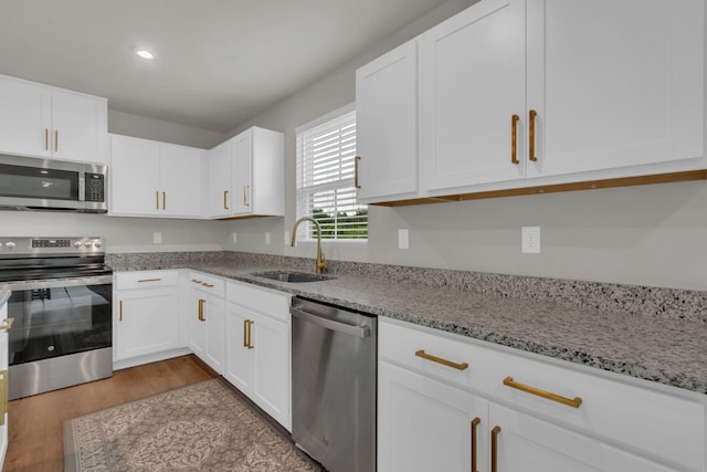 1830 Quail Run Way, Spring Hill, TN 37174 - kitchen with appliances with stainless steel finishes, wood finished floors, white cabinets, light stone countertops, and recessed lighting