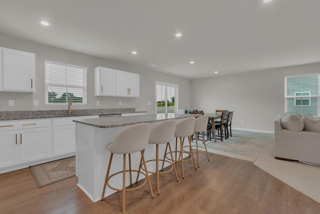 1830 Quail Run Way, Spring Hill, TN 37174 - kitchen with open floor plan, a kitchen island, a breakfast bar area, recessed lighting, and light wood-style flooring