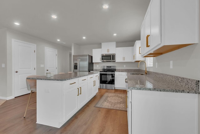 1830 Quail Run Way, Spring Hill, TN 37174 - kitchen featuring stainless steel appliances, light wood-style floors, a kitchen island, recessed lighting, and stone countertops