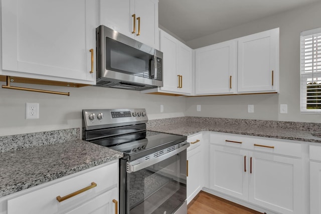 1830 Quail Run Way, Spring Hill, TN 37174 - kitchen featuring stainless steel appliances, white cabinets, light stone countertops, and light wood finished floors