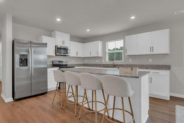 1830 Quail Run Way, Spring Hill, TN 37174 - kitchen featuring stainless steel appliances, a kitchen island, white cabinets, a breakfast bar, and recessed lighting