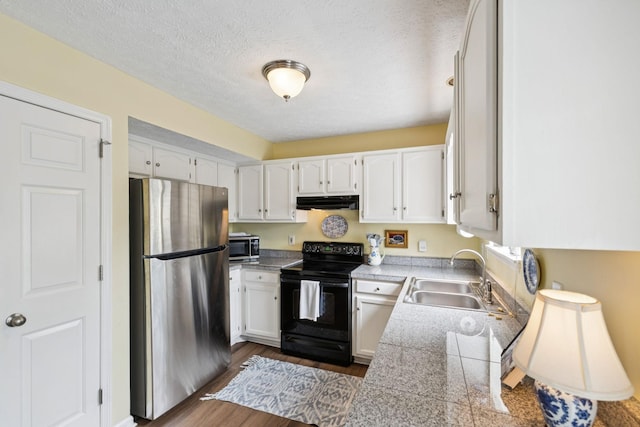 306 Norvich Ct, Franklin, TN 37069 - kitchen featuring appliances with stainless steel finishes, tile countertops, white cabinets, under cabinet range hood, and a textured ceiling