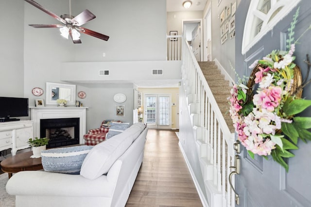 306 Norvich Ct, Franklin, TN 37069 - living area featuring a towering ceiling, stairs, wood finished floors, a fireplace, and a ceiling fan