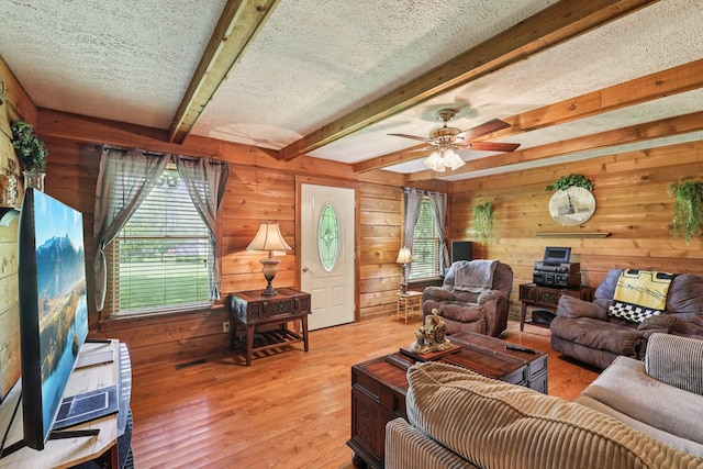 10615 Owens Chapel Rd, Springfield, TN 37172 - living room with wooden walls, beamed ceiling, light wood-style flooring, ceiling fan, and a textured ceiling