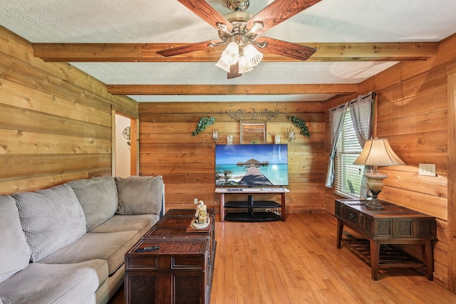 10615 Owens Chapel Rd, Springfield, TN 37172 - living area with wooden walls, beam ceiling, light wood-type flooring, a ceiling fan, and a textured ceiling
