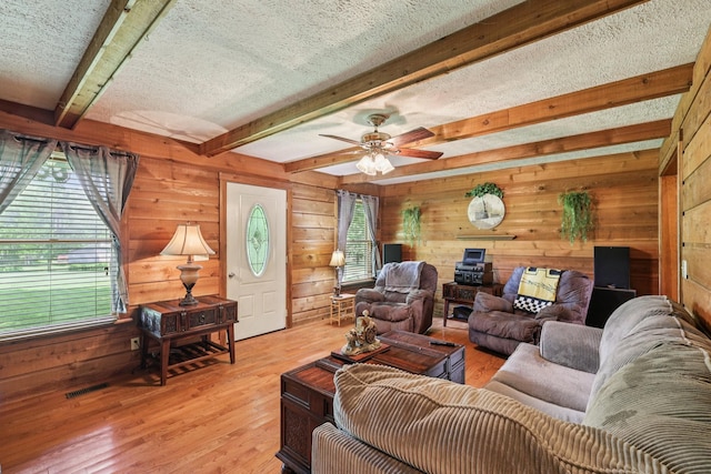 10615 Owens Chapel Rd, Springfield, TN 37172 - living area featuring wooden walls, light wood-style flooring, beamed ceiling, a textured ceiling, and a ceiling fan