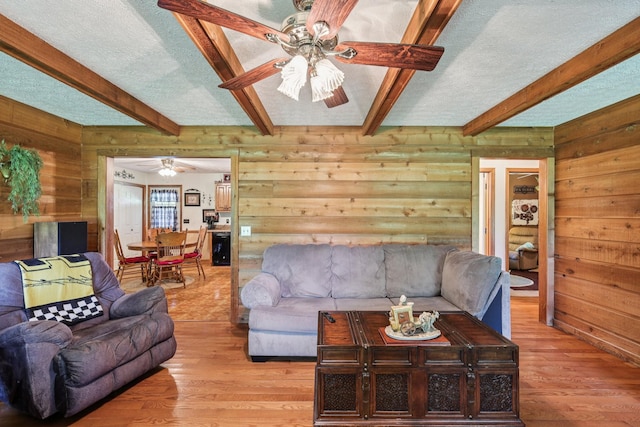 10615 Owens Chapel Rd, Springfield, TN 37172 - living room featuring ceiling fan, wooden walls, light wood-type flooring, beamed ceiling, and a textured ceiling