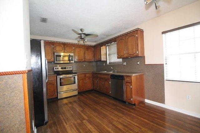 1211 Patton Pl, Oak Grove, KY 42262 - kitchen featuring appliances with stainless steel finishes, ceiling fan, dark wood-style floors, and brown cabinetry