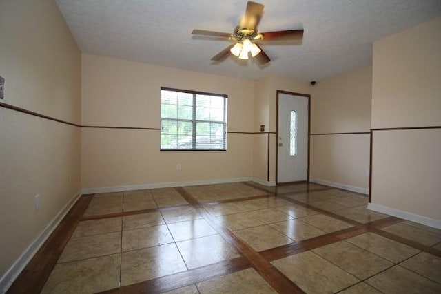 1211 Patton Pl, Oak Grove, KY 42262 - tiled empty room featuring inlaid floor details, a ceiling fan, and a textured ceiling