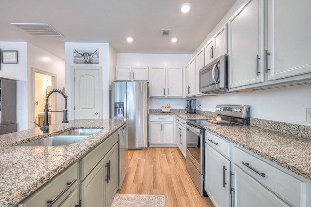 3105 Defilade Dr, Murfreesboro, TN 37128 - kitchen featuring stainless steel appliances, light wood-style floors, light stone countertops, recessed lighting, and white cabinets