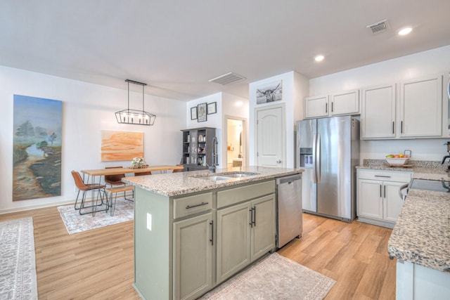 3105 Defilade Dr, Murfreesboro, TN 37128 - kitchen with appliances with stainless steel finishes, light wood-type flooring, an island with sink, light stone countertops, and recessed lighting