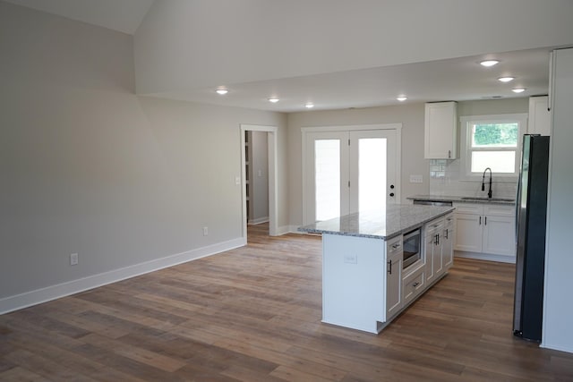 825B College St, Portland, TN 37148 - kitchen with stainless steel appliances, white cabinetry, dark wood-style floors, a kitchen island, and tasteful backsplash