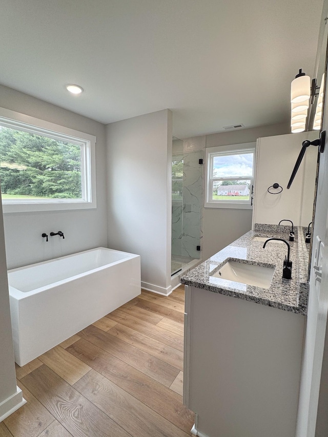 825B College St, Portland, TN 37148 - full bath with a freestanding tub, a shower stall, double vanity, wood finished floors, and recessed lighting