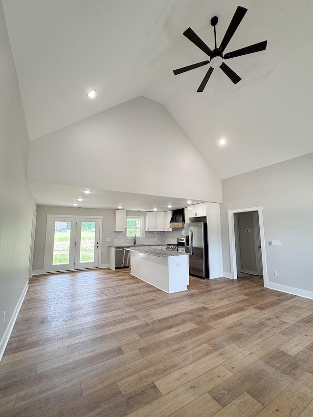 825B College St, Portland, TN 37148 - kitchen featuring open floor plan, appliances with stainless steel finishes, custom range hood, high vaulted ceiling, and white cabinetry