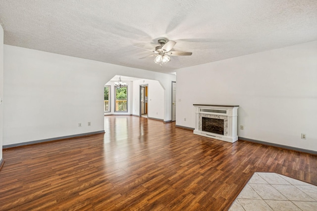 5531 Willow Oak Dr, Baxter, TN 38544 - unfurnished living room with ceiling fan, a chandelier, wood finished floors, a premium fireplace, and a textured ceiling