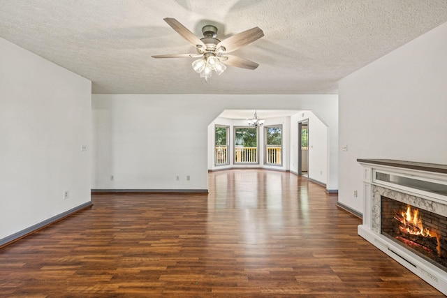 5531 Willow Oak Dr, Baxter, TN 38544 - unfurnished living room with a chandelier, a fireplace, wood finished floors, a textured ceiling, and a ceiling fan
