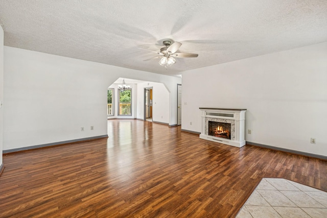 5531 Willow Oak Dr, Baxter, TN 38544 - unfurnished living room with a ceiling fan, wood finished floors, a chandelier, a fireplace, and a textured ceiling