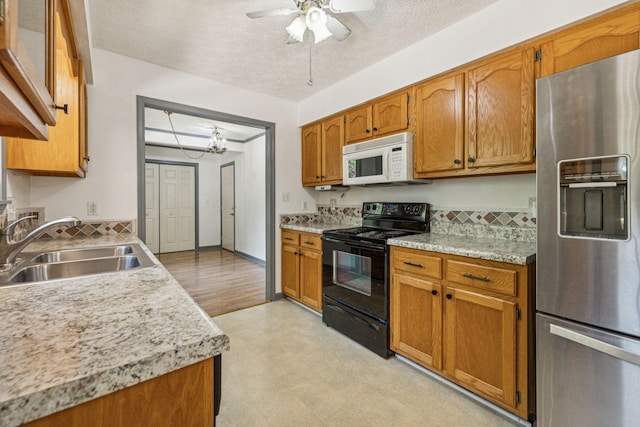5531 Willow Oak Dr, Baxter, TN 38544 - kitchen featuring stainless steel fridge, black range with electric stovetop, white microwave, light floors, and a ceiling fan