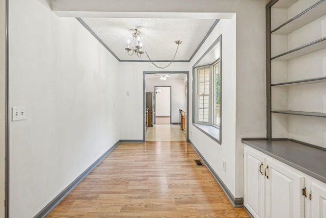 5531 Willow Oak Dr, Baxter, TN 38544 - hallway featuring light wood-type flooring, a chandelier, crown molding, and built in shelves