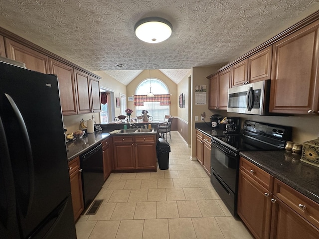 1239 Wentworth Dr, Gallatin, TN 37066 - kitchen with black appliances, dark countertops, vaulted ceiling, a peninsula, and light tile patterned floors