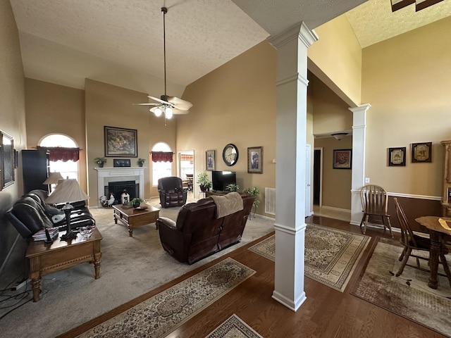 1239 Wentworth Dr, Gallatin, TN 37066 - living area featuring ornate columns, ceiling fan, high vaulted ceiling, a textured ceiling, and a fireplace