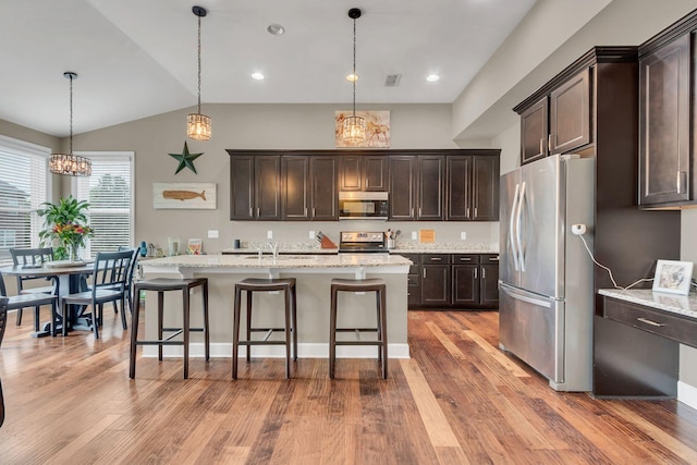 1060 Harvey Springs Dr, Spring Hill, TN 37174 - kitchen with stainless steel appliances, dark brown cabinetry, a kitchen breakfast bar, light wood finished floors, and lofted ceiling