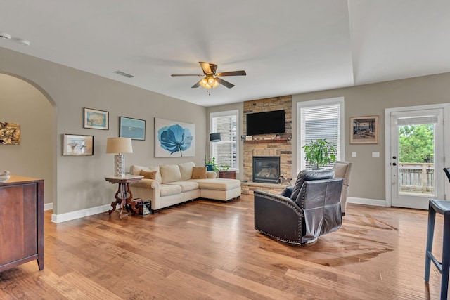 1060 Harvey Springs Dr, Spring Hill, TN 37174 - living area with a ceiling fan, arched walkways, a stone fireplace, and light wood-style flooring