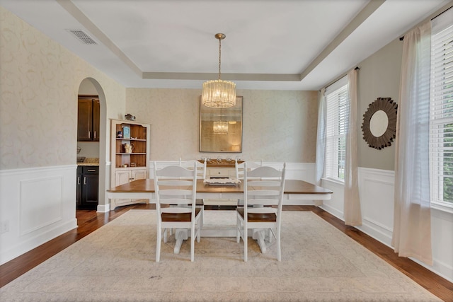 1060 Harvey Springs Dr, Spring Hill, TN 37174 - dining space with dark wood finished floors, wainscoting, a tray ceiling, a chandelier, and arched walkways