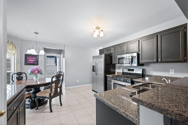256 Granger View Cir, Franklin, TN 37064 - kitchen with appliances with stainless steel finishes, a chandelier, dark stone countertops, pendant lighting, and light tile patterned floors