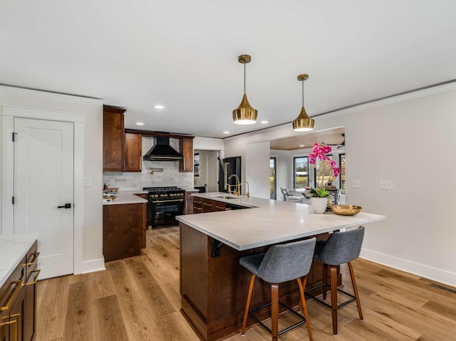 1015 Jump Off Rd, Bon Aqua, TN 37025 - kitchen featuring wall chimney range hood, high quality appliances, light countertops, backsplash, and crown molding