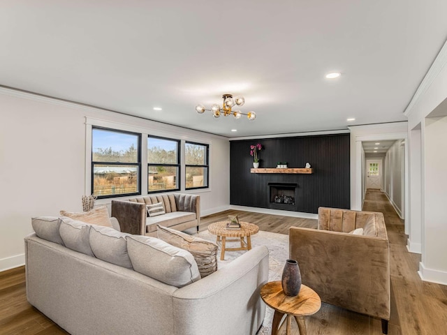 1015 Jump Off Rd, Bon Aqua, TN 37025 - living room featuring recessed lighting, ornamental molding, wood finished floors, a chandelier, and a fireplace
