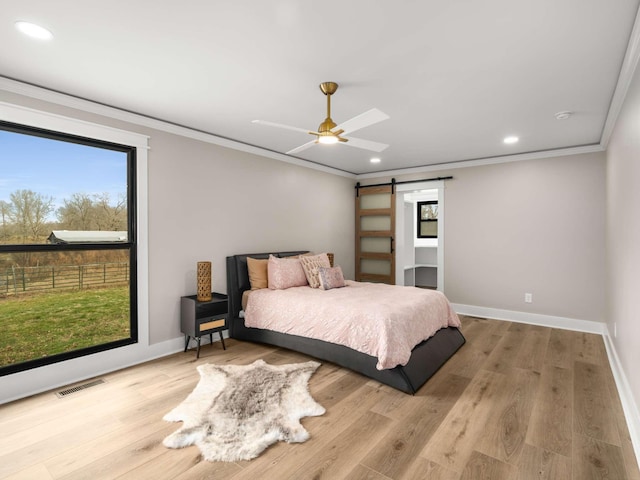1015 Jump Off Rd, Bon Aqua, TN 37025 - bedroom with a barn door, ornamental molding, recessed lighting, wood finished floors, and ceiling fan