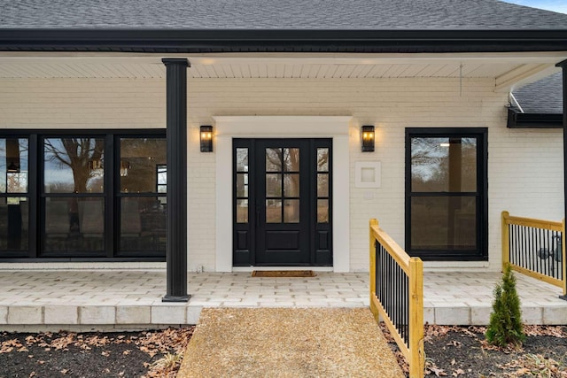 1015 Jump Off Rd, Bon Aqua, TN 37025 - doorway to property featuring brick siding, a shingled roof, and covered porch
